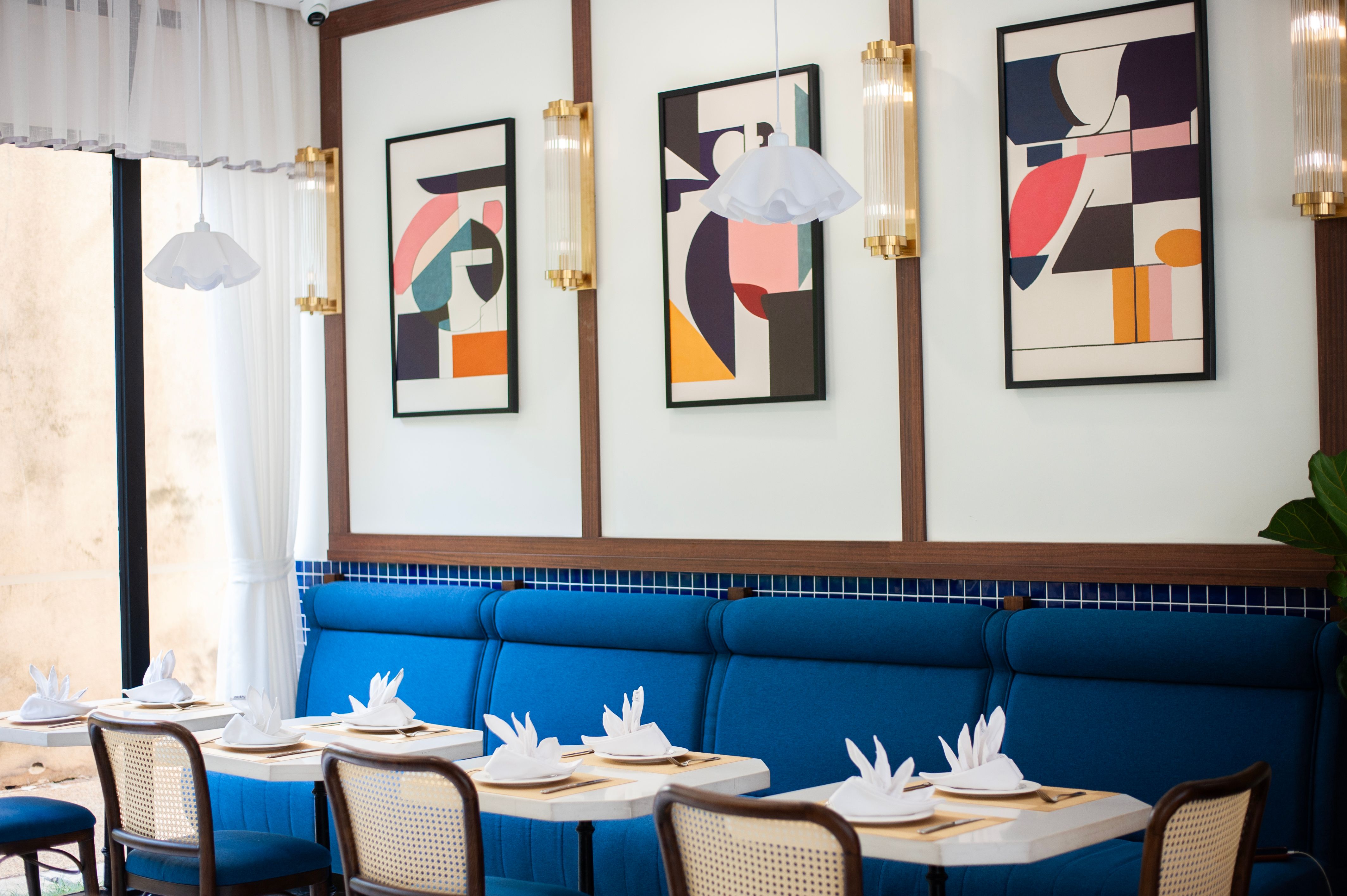 Stylish restaurant interior with abstract art and elegant table setting, perfect for dining concepts.