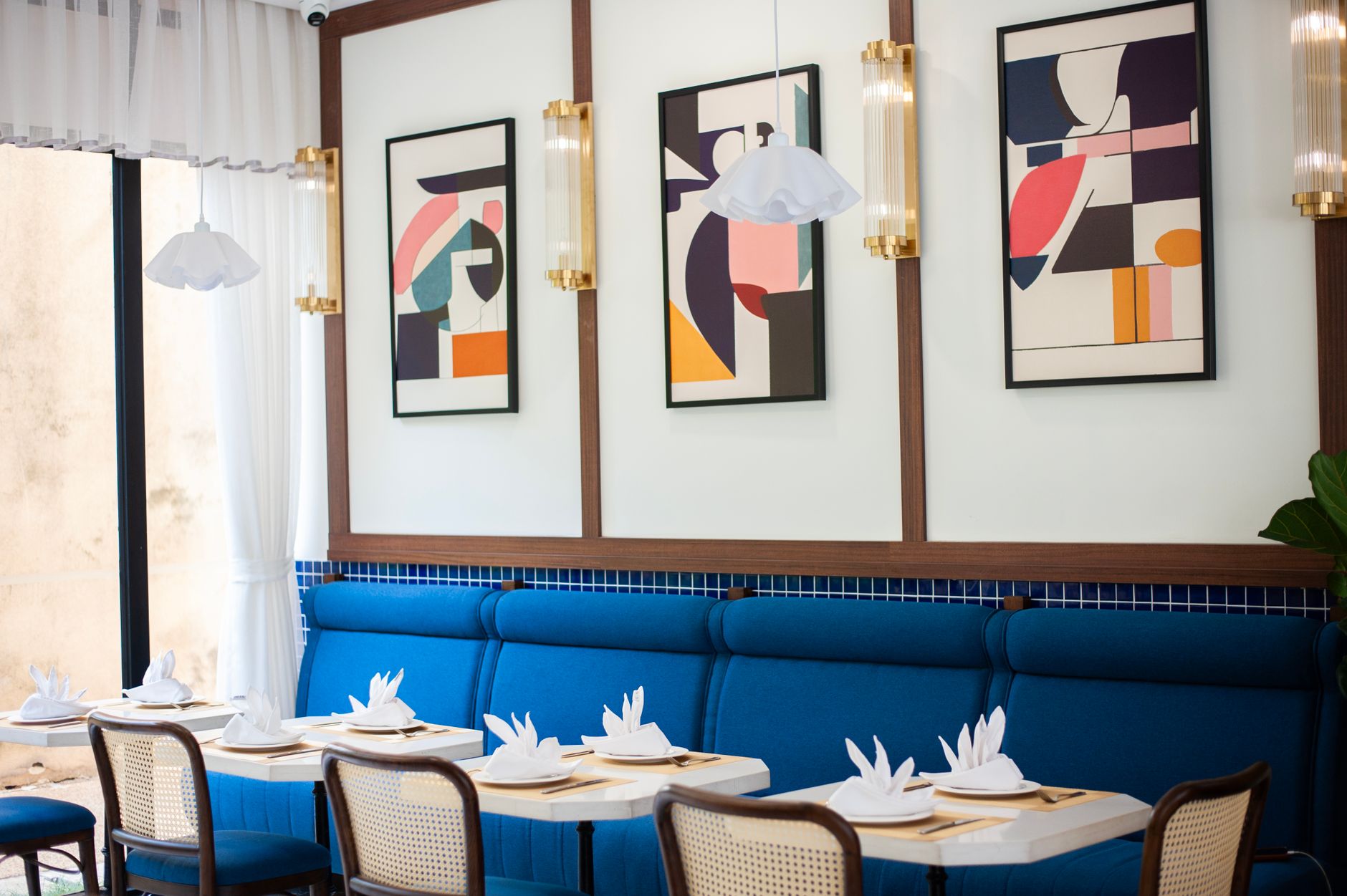 Stylish restaurant interior with abstract art and elegant table setting, perfect for dining concepts.