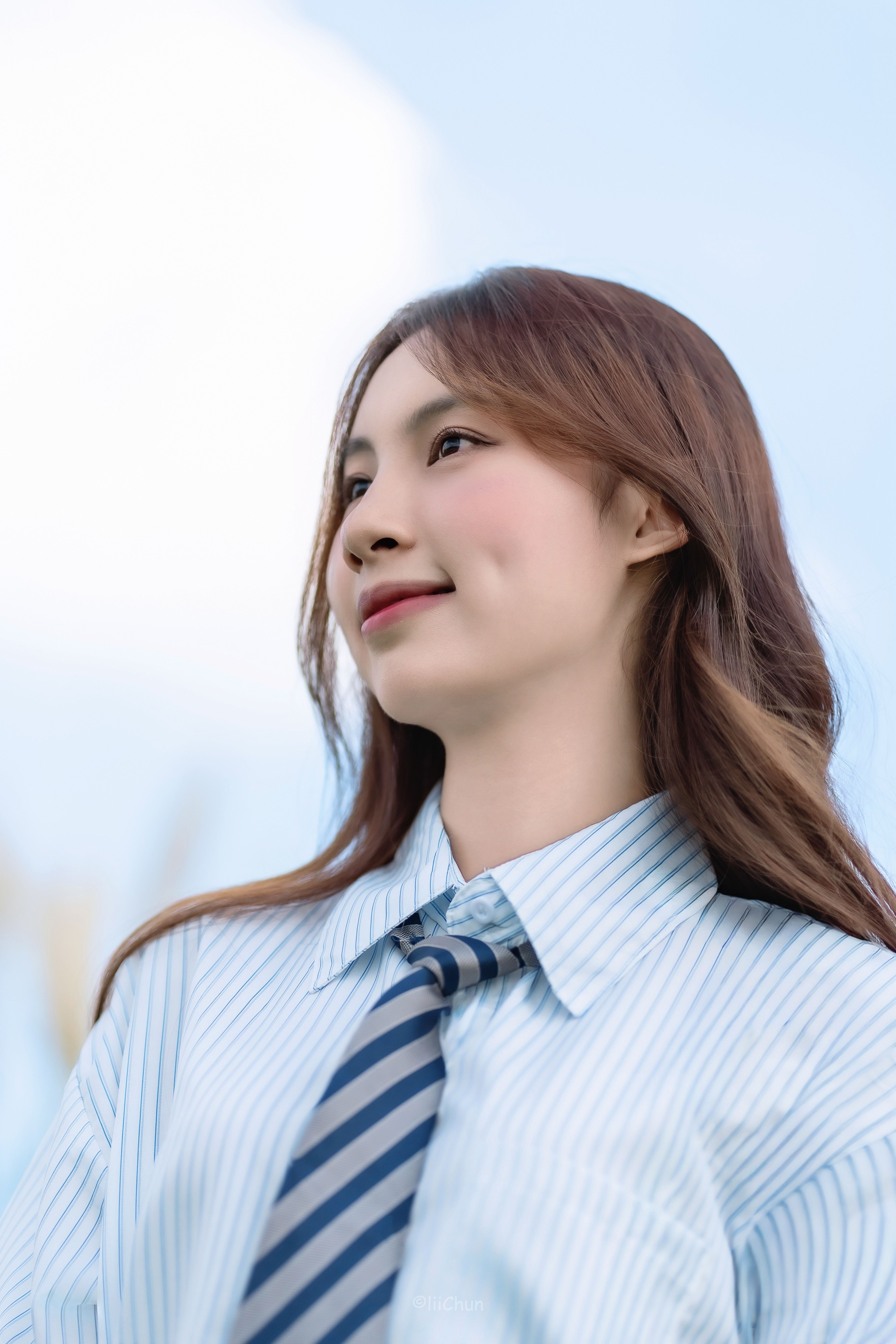 Young Woman Smiling Outdoors in Blue Sky · Free Stock Photo