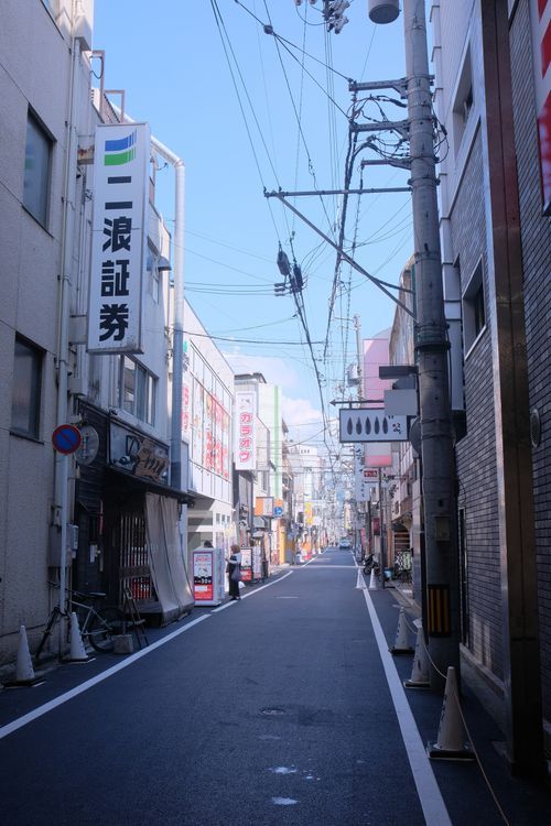 Free Quiet city street in Japan on a sunny day, featuring power lines and signage. Stock Photo
