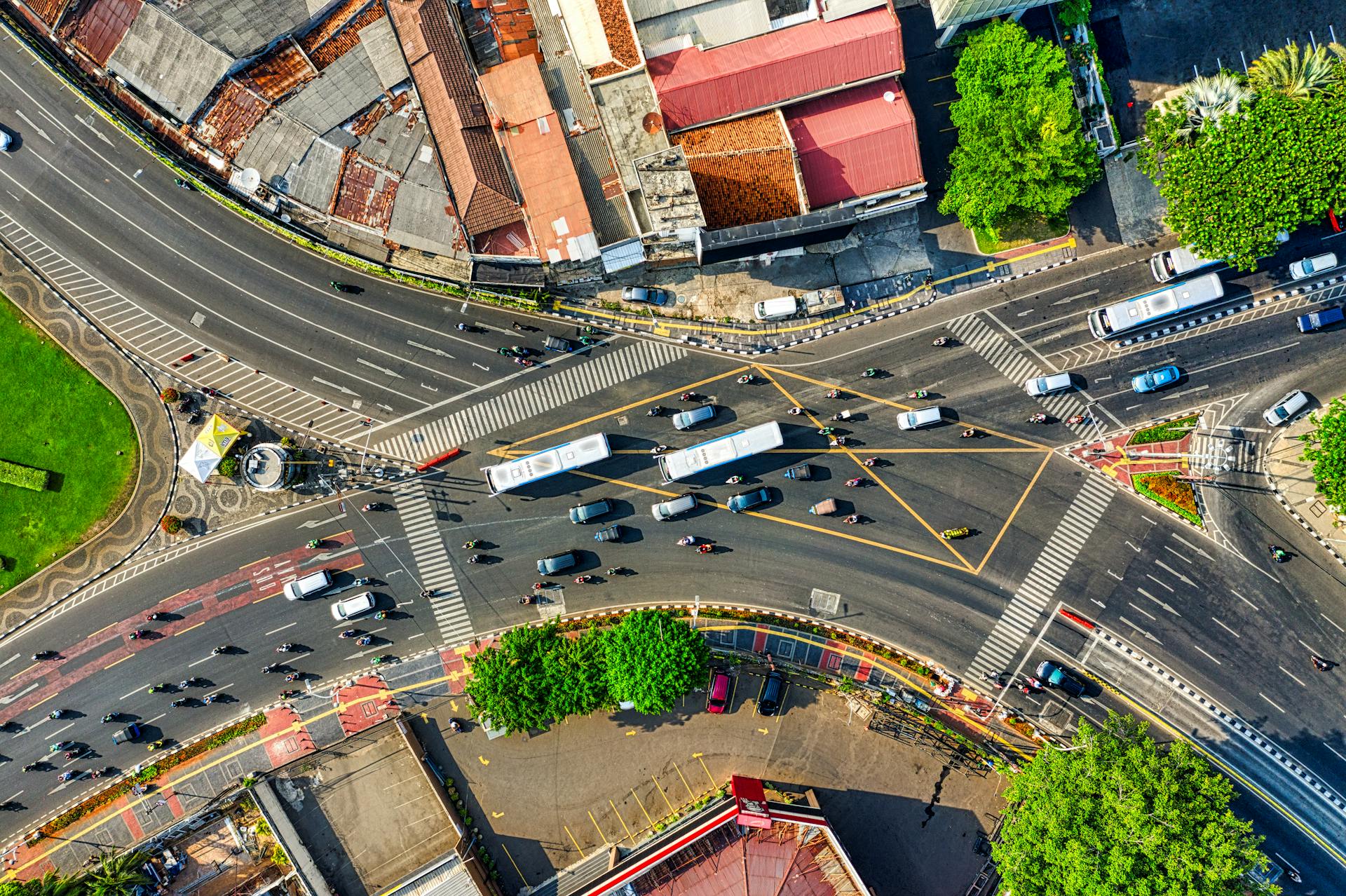 Dynamic aerial view of a busy urban intersection in Jakarta, showcasing city traffic and infrastructure.