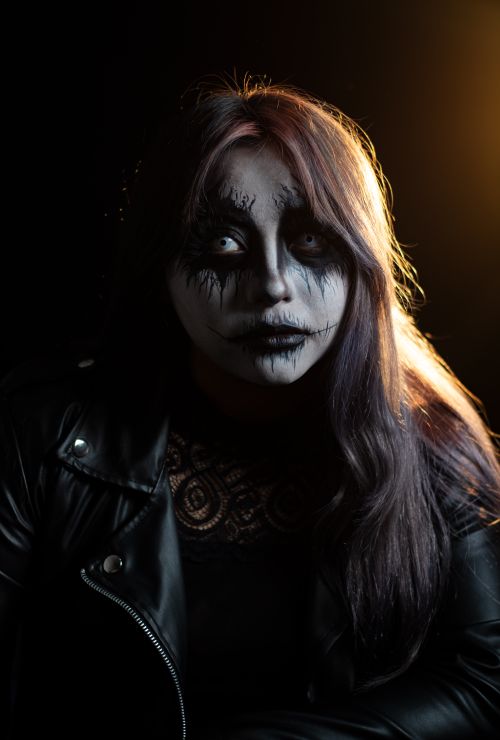 Free Dramatic portrait featuring intricate Halloween makeup under moody lighting. Stock Photo