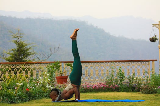 Woman practicing yoga pose outdoors in Rishikesh with scenic mountain backdrop.