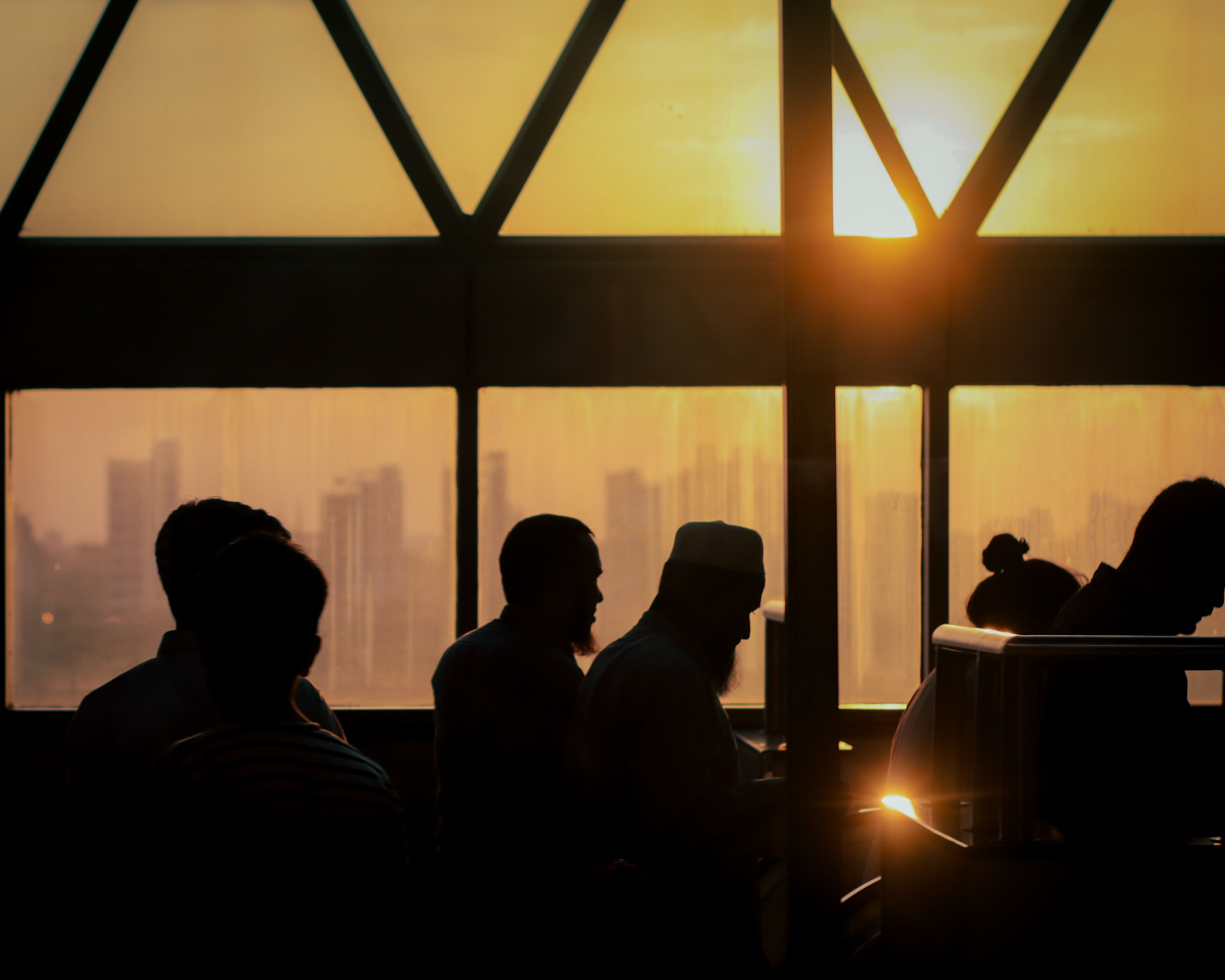 Silhouetted People at Sunset Overlooking Cityscape · Free Stock Photo