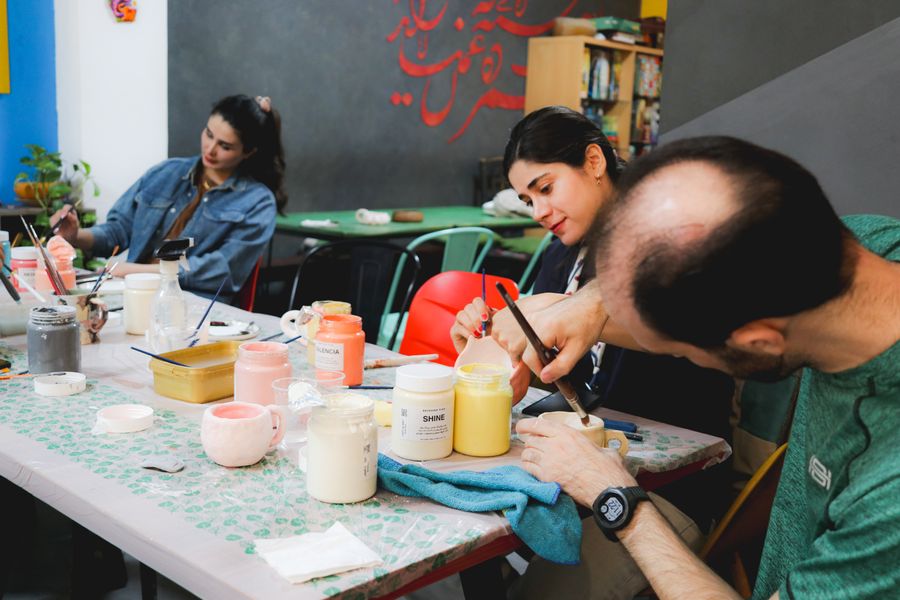 Adults working on ceramic pieces in a pottery class