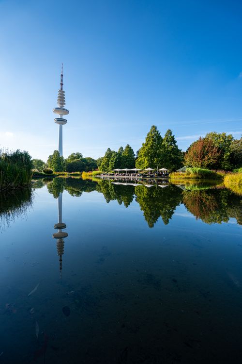 Free A scenic view of a television tower reflected in a tranquil lake surrounded by nature. Stock Photo