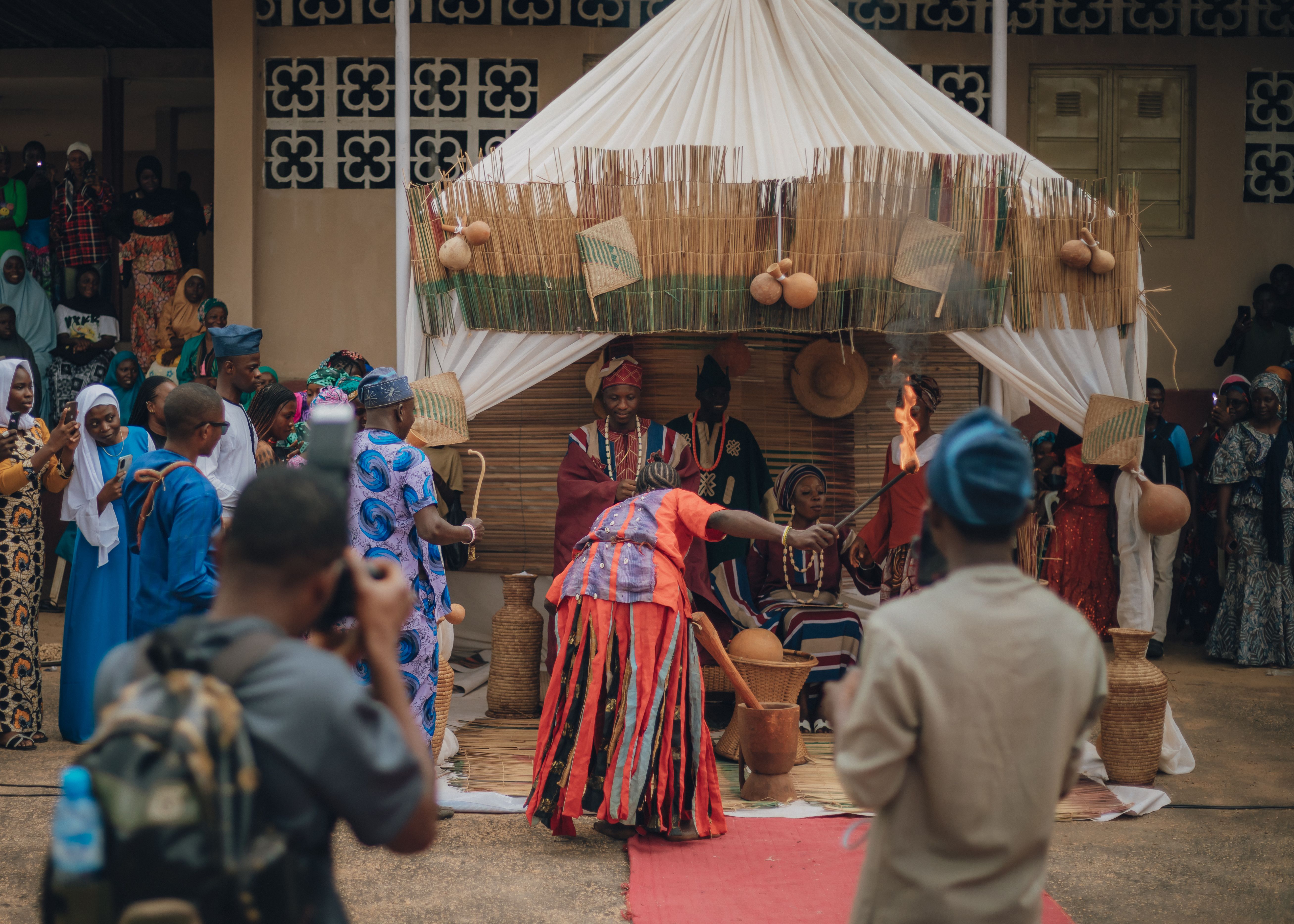 A vibrant traditional African ceremony with people in colorful ethnic attire taking part in a cultural ritual.