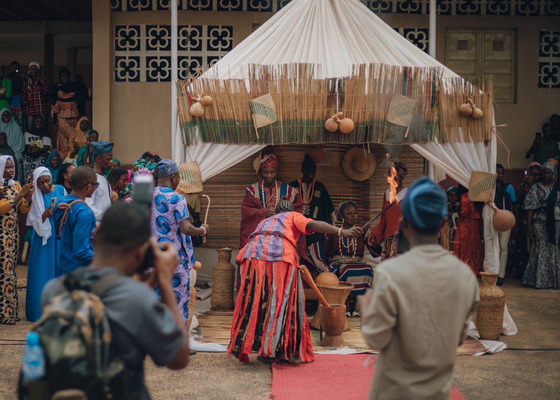A vibrant traditional African ceremony with people in colorful ethnic attire taking part in a cultural ritual.
