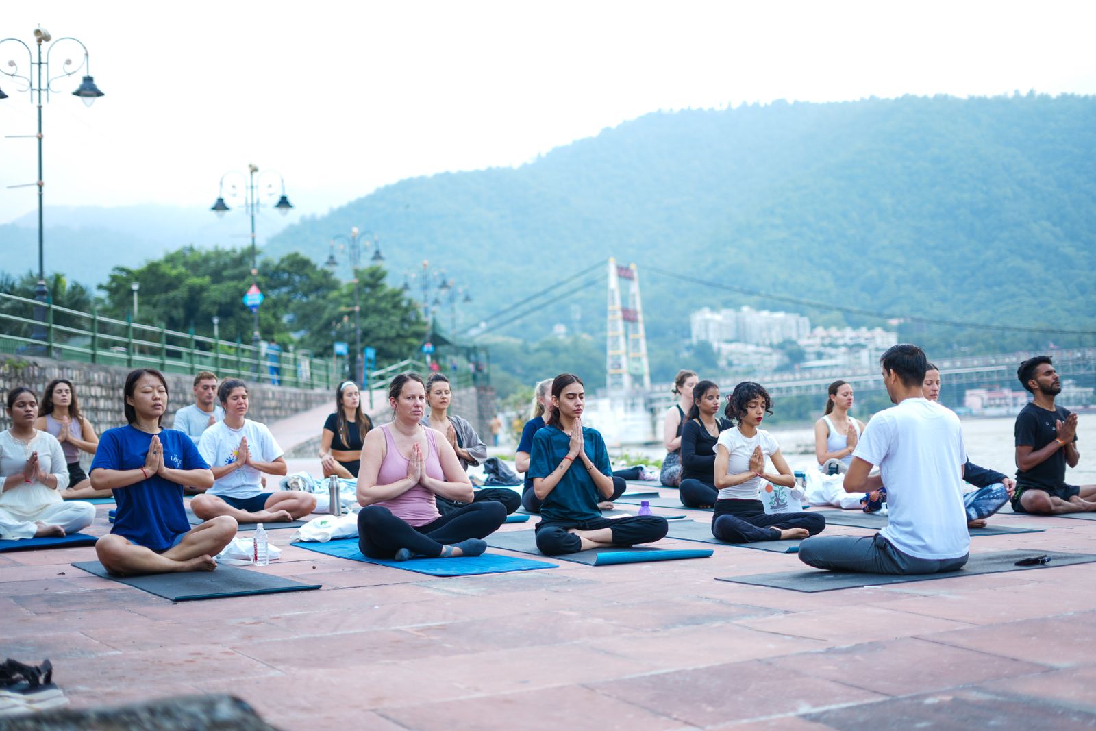 Woman meditating in lotus position outdoors representing the aim of yoga as inner stillness