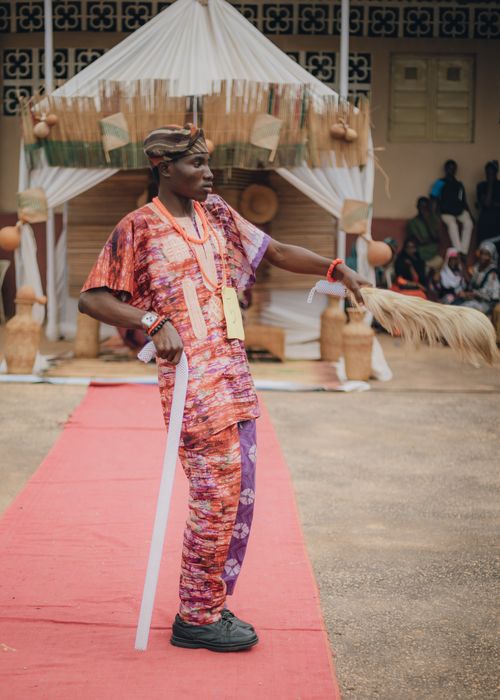 Free Man in vibrant traditional attire during a cultural event holding a horsetail switch. Stock Photo