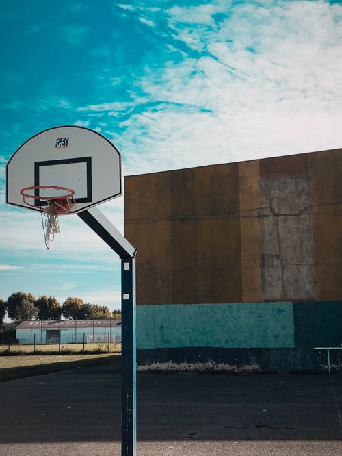 Free Empty outdoor basketball court with a hoop and blue sky. Stock Photo