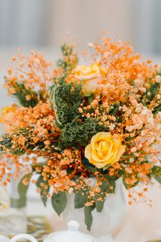 Bright and vivid floral bouquet featuring yellow roses and orange baby's breath.