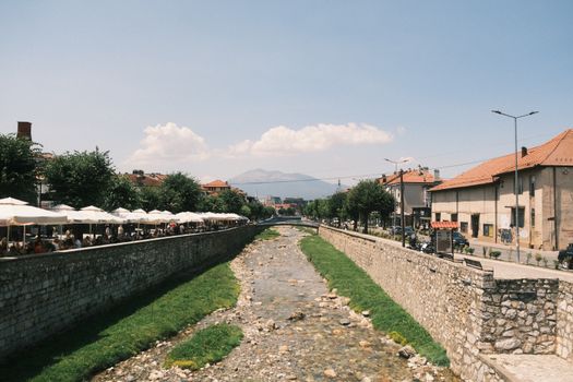 Captivating view of Prizren river with cityscape and outdoor cafes in summer