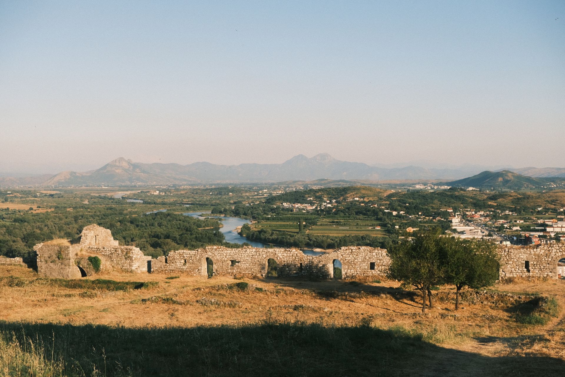 A panoramic view of the Albanian landscape and Shkodër Castle ruins from Rozafa Castle during a summer day.