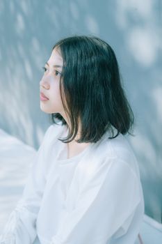 柔和的阳光下，一位年轻女子静坐的美丽肖像，展现了宁静与优雅