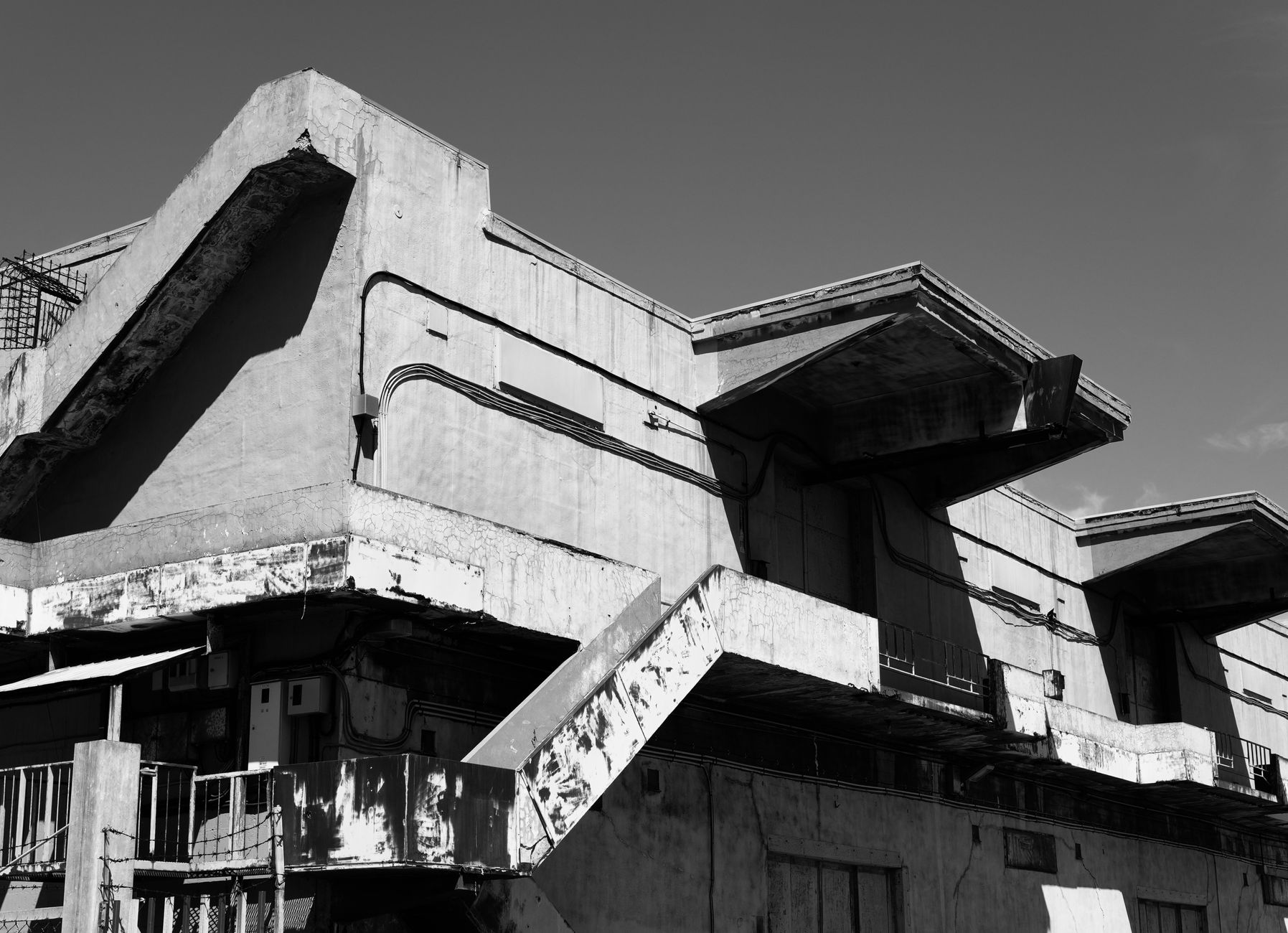 Black and white photo of a weathered concrete building in Otaru, Japan showcasing industrial architecture.. black, white, pho