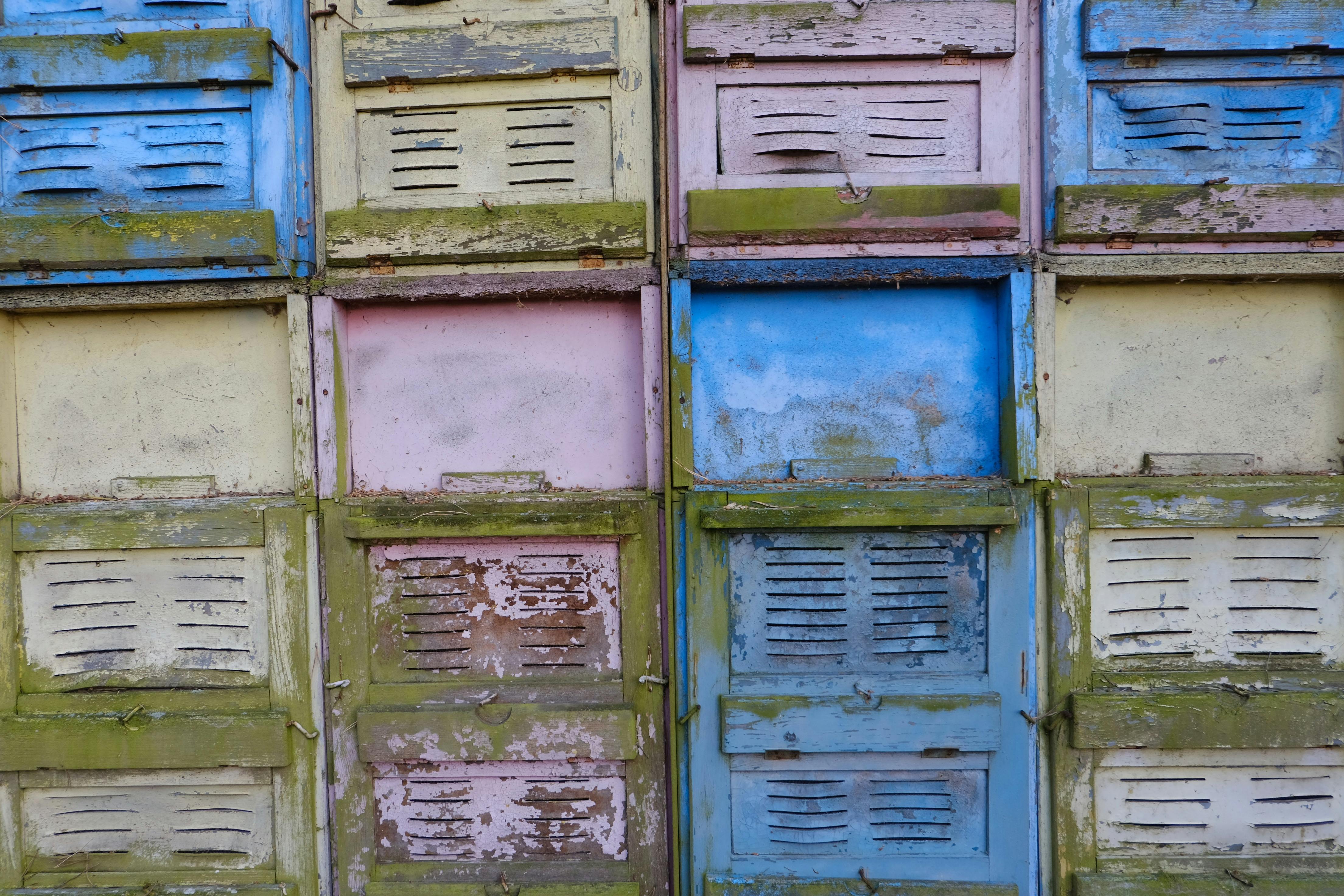Gratis Una parete colorata e usurata composta da vecchie persiane in legno in tonalità pastello. Foto a disposizione