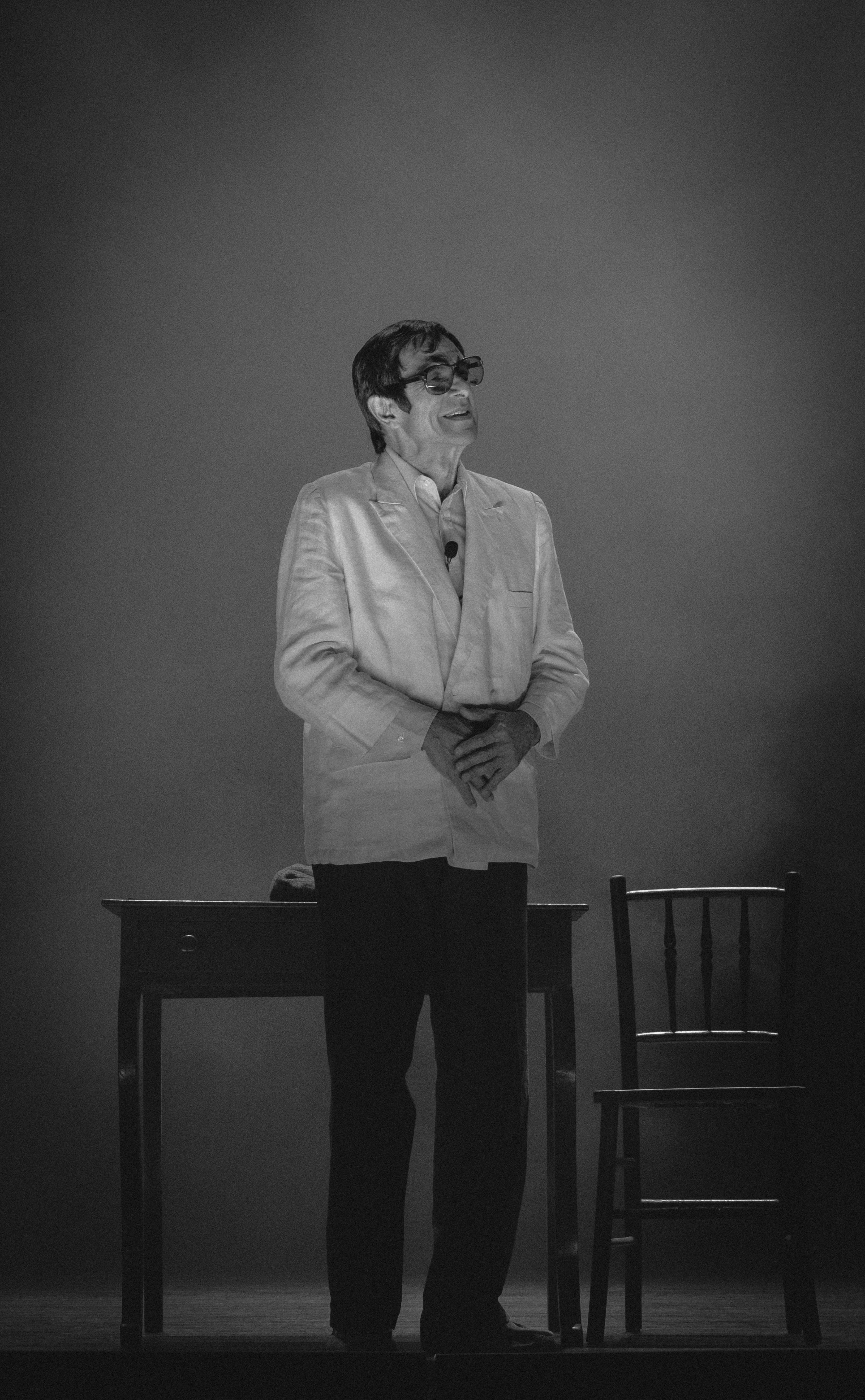 Free Elegant black and white portrait of a performer standing on stage with a classic demeanor. Stock Photo