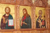 Detailed traditional religious icon paintings on a wooden church wall.