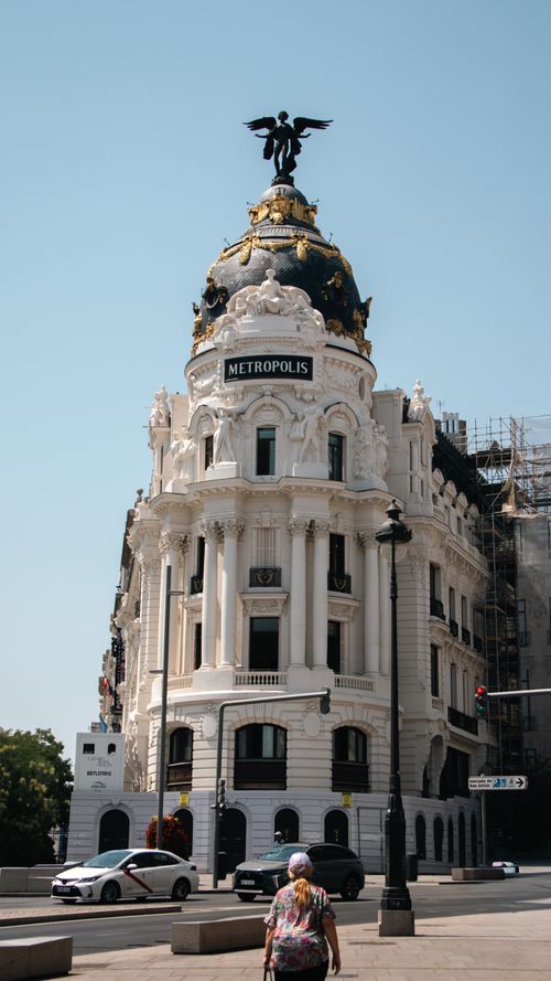 Free Elegant architectural shot of the iconic Metropolis Building in Madrid, Spain with blue sky and street view. Stock Photo