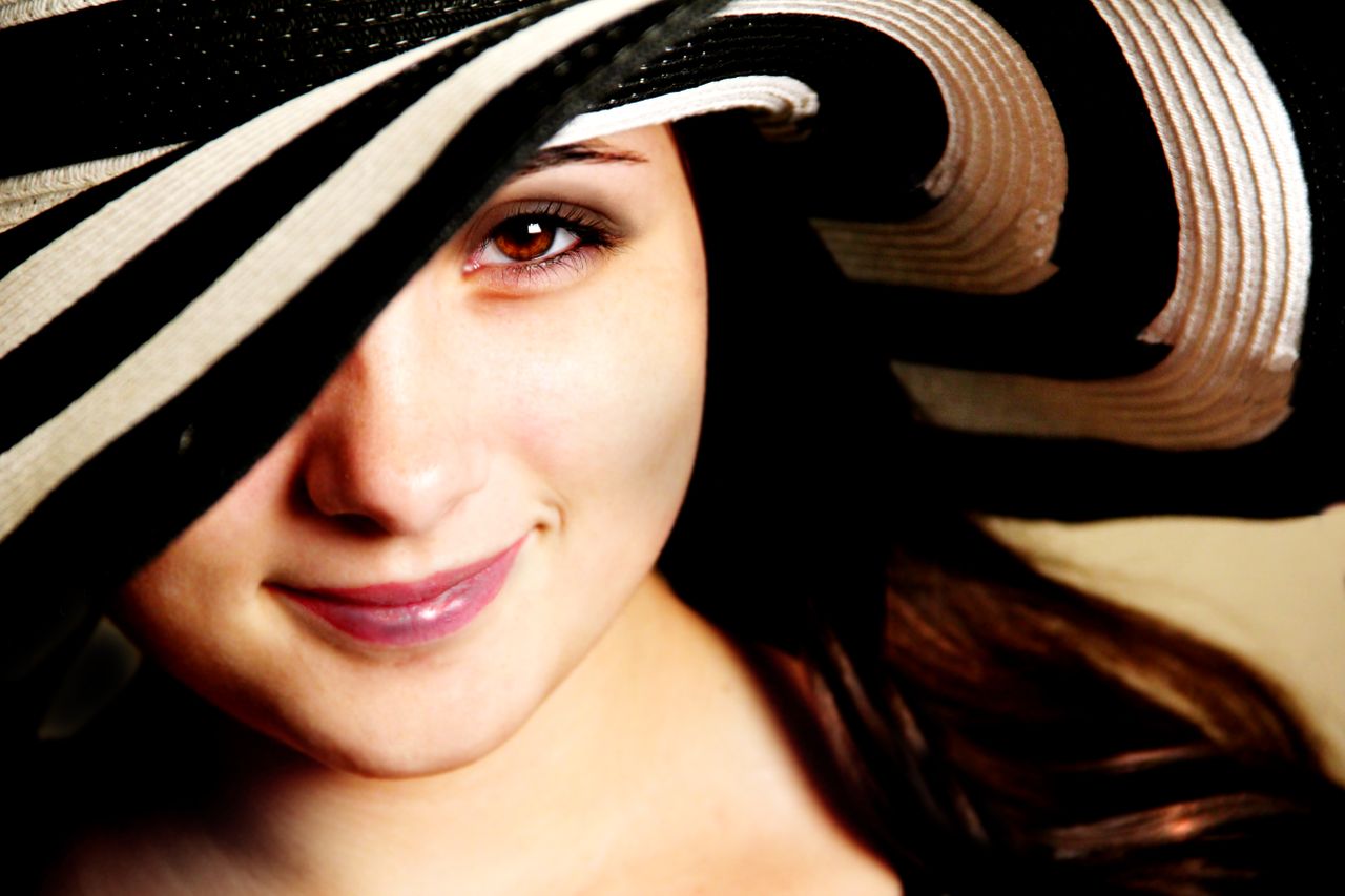 close up portrait of a smiling woman wearing a chic striped hat