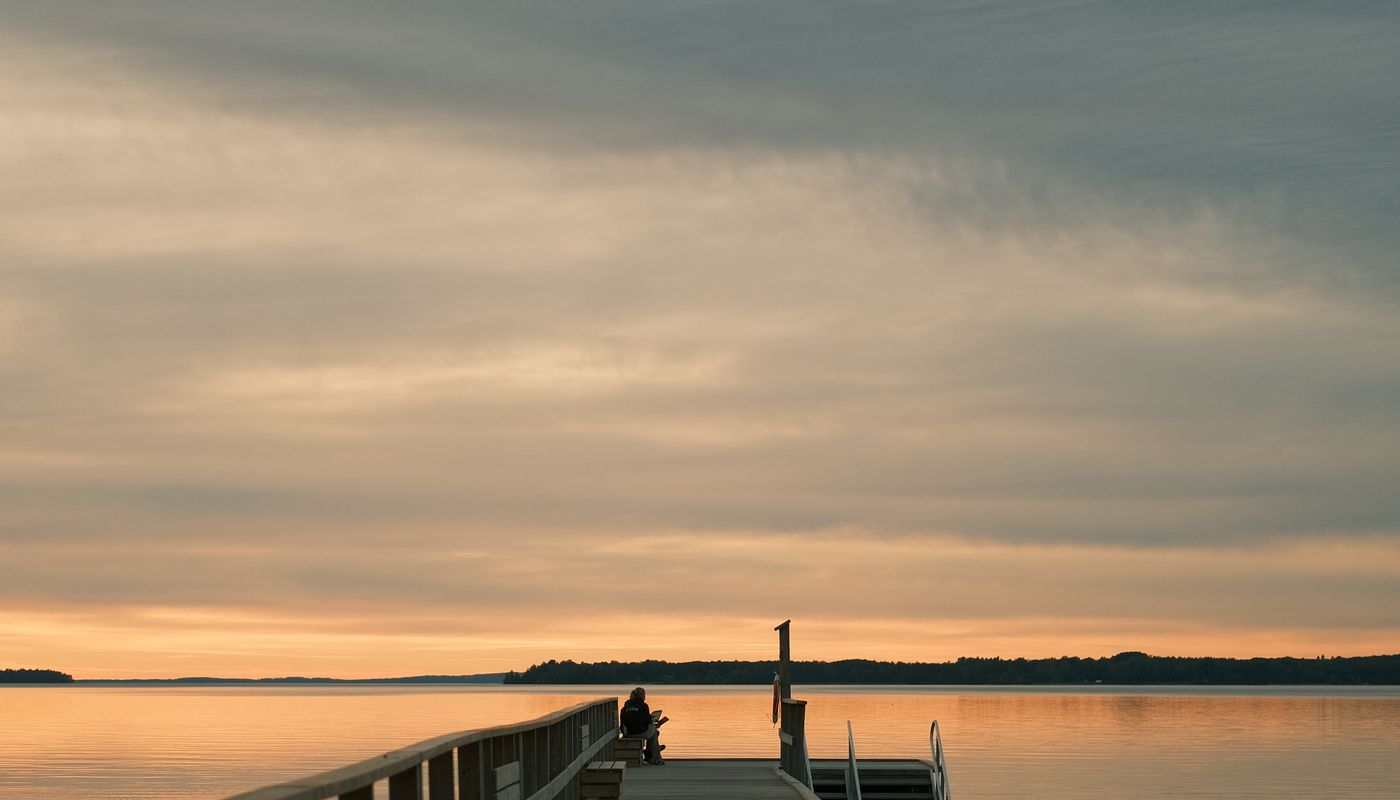 A wooden dock extending over still water at sunrise