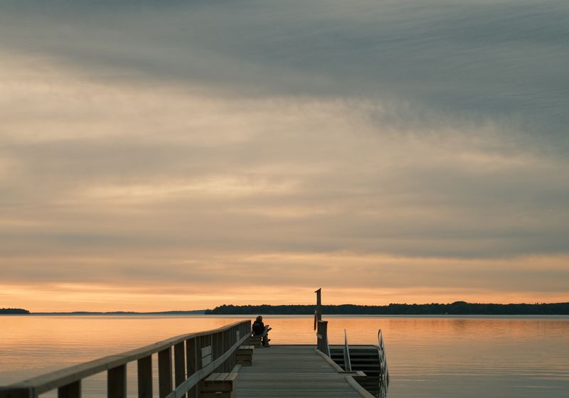A wooden dock extending over still water at sunrise