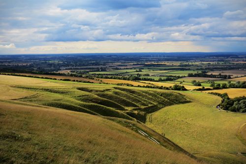 Free Expansive landscape of rolling green hills under a dynamic sky, perfect for nature lovers. Stock Photo