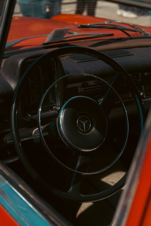 Free Close-up of a vintage car's steering wheel and dashboard, showcasing classic automotive design. Stock Photo