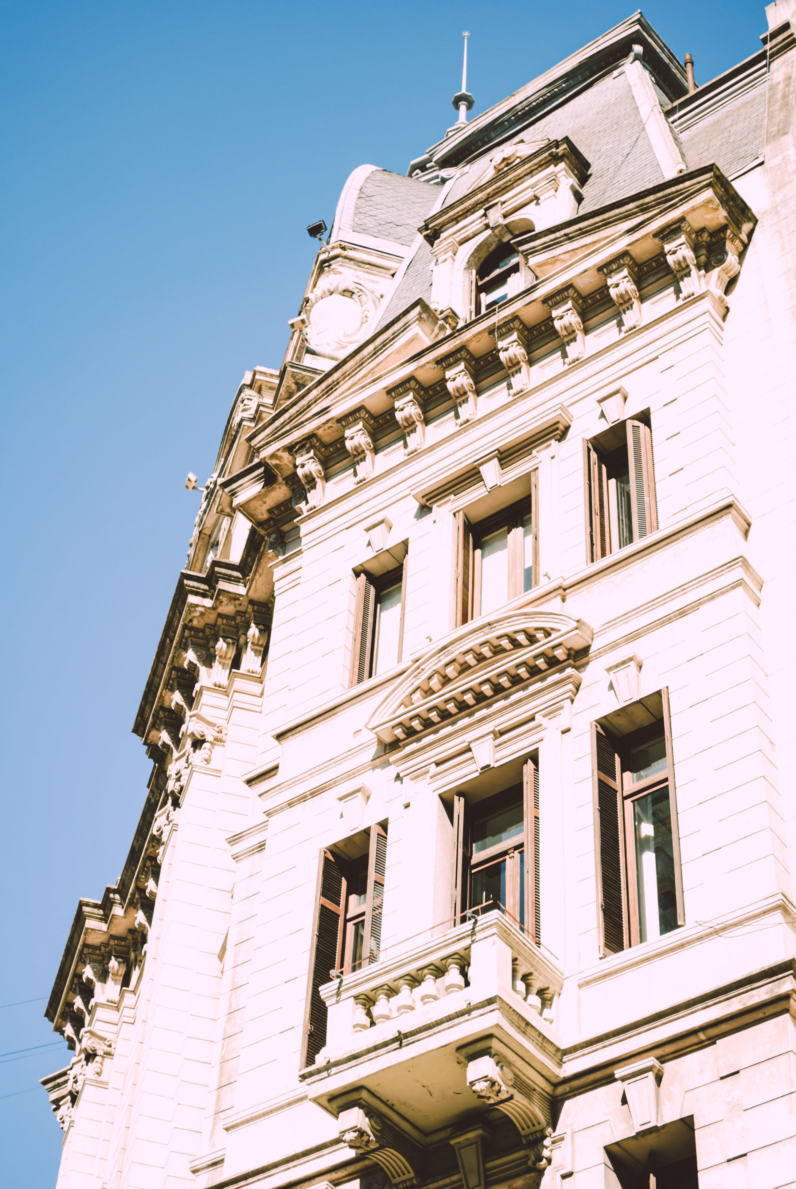 Elegant historic building facade in European architectural style against a clear blue sky.