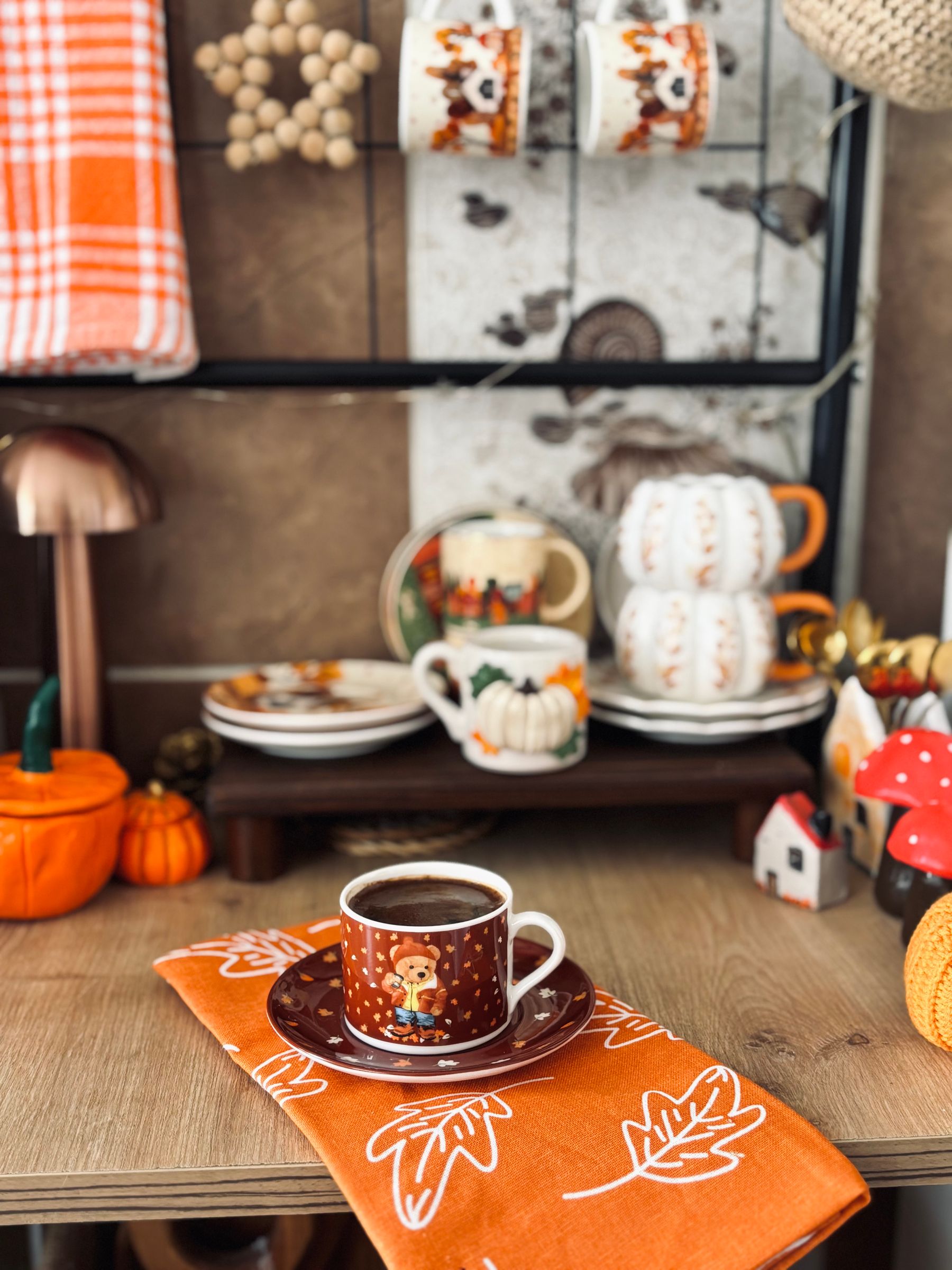 Autumn coffee vignette with mug and small pumpkin in a warm living room