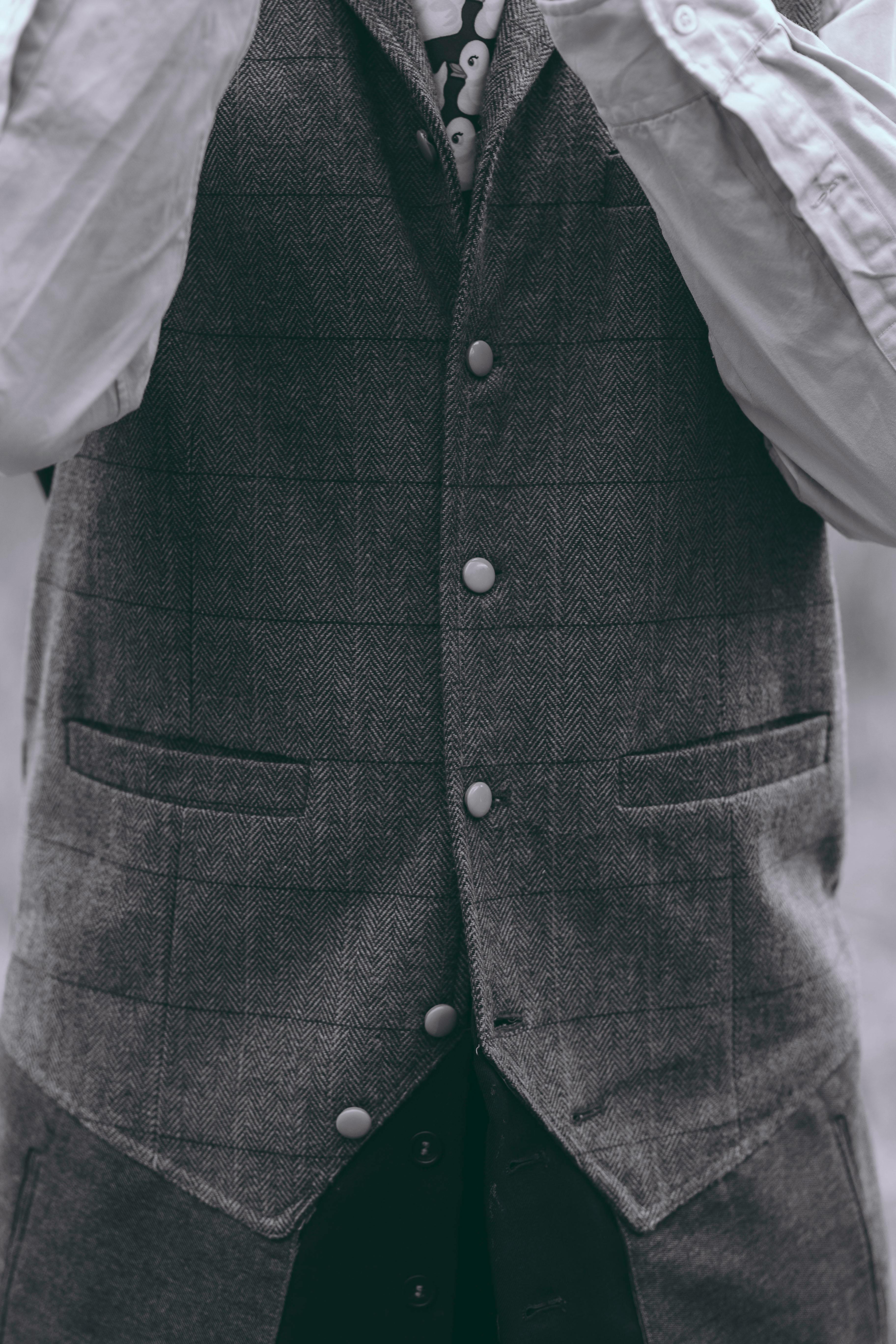 Zadarmo Umelecký čiernobiely portrét osoby v štýlovej sivej veste, zachytávajúci eleganciu inšpirovanú vintage štýlom. Fotka z fotobanky