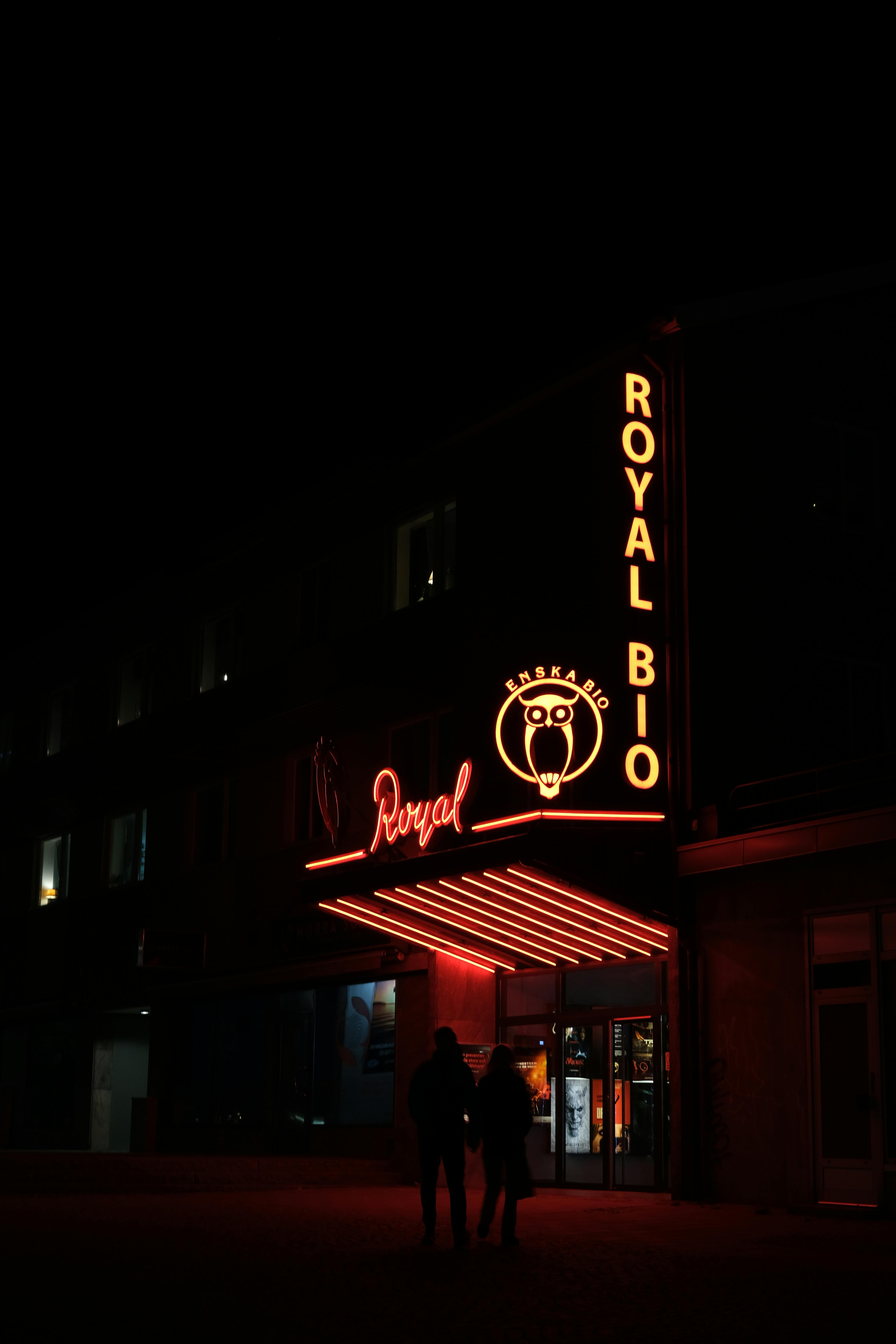 Gratuit O intrare de cinema vibrantă, luminată cu neon, noaptea, cu siluete de siluete. Fotografie de stoc