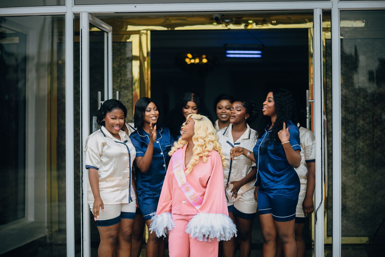 A joyful bride and her bridesmaids in coordinated matching outfits celebrating together