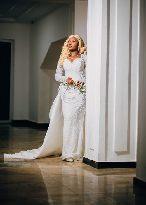 Free A bride in a stunning white gown poses gracefully indoors, exuding elegance. Stock Photo