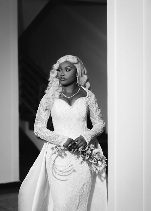 Free Classy black and white photo of a bride indoors holding a bouquet. Stock Photo
