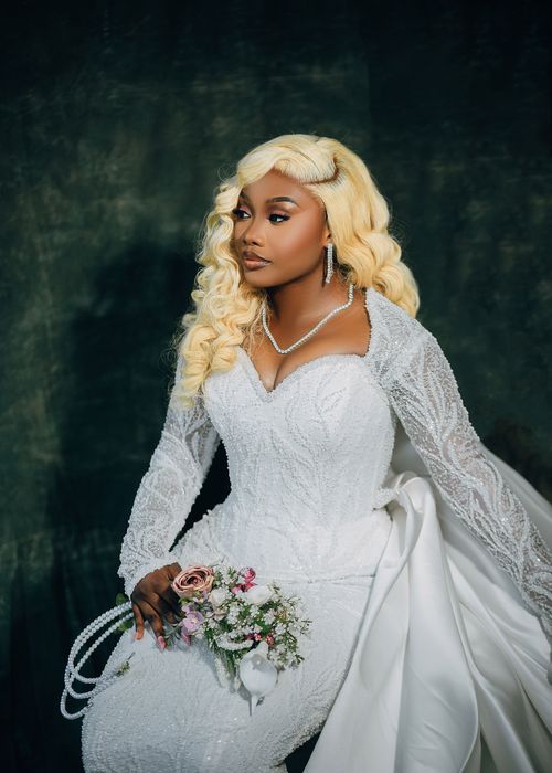 Free An elegant black bride in a beautiful white lace wedding dress holding a bouquet. Stock Photo
