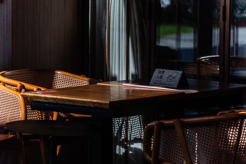 Free Sunlit cafe table setting with natural rattan chairs and empty seating, creating a cozy atmosphere. Stock Photo