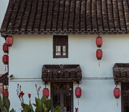 Free A traditional Chinese house adorned with red lanterns and overhanging tiles. Stock Photo