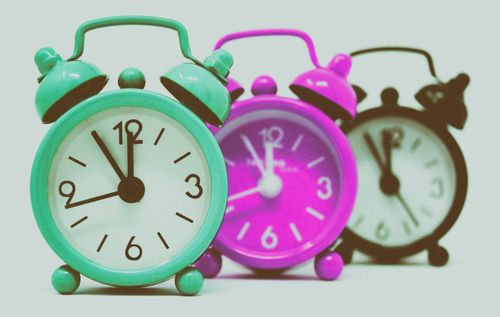 Free Vibrant set of vintage alarm clocks in teal, pink, and black. Stock Photo