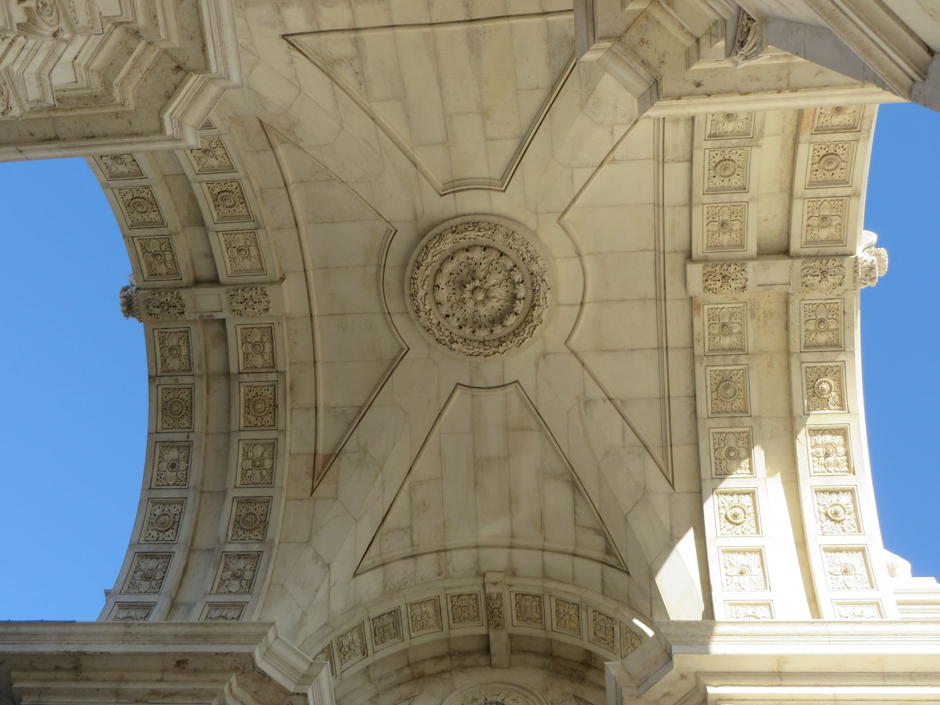 Intricate architectural details of the Triumphal Arch in Lisbon captured from below.