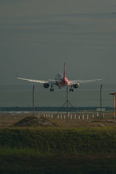 A commercial airplane landing on the runway during the day, capturing aviation in action.