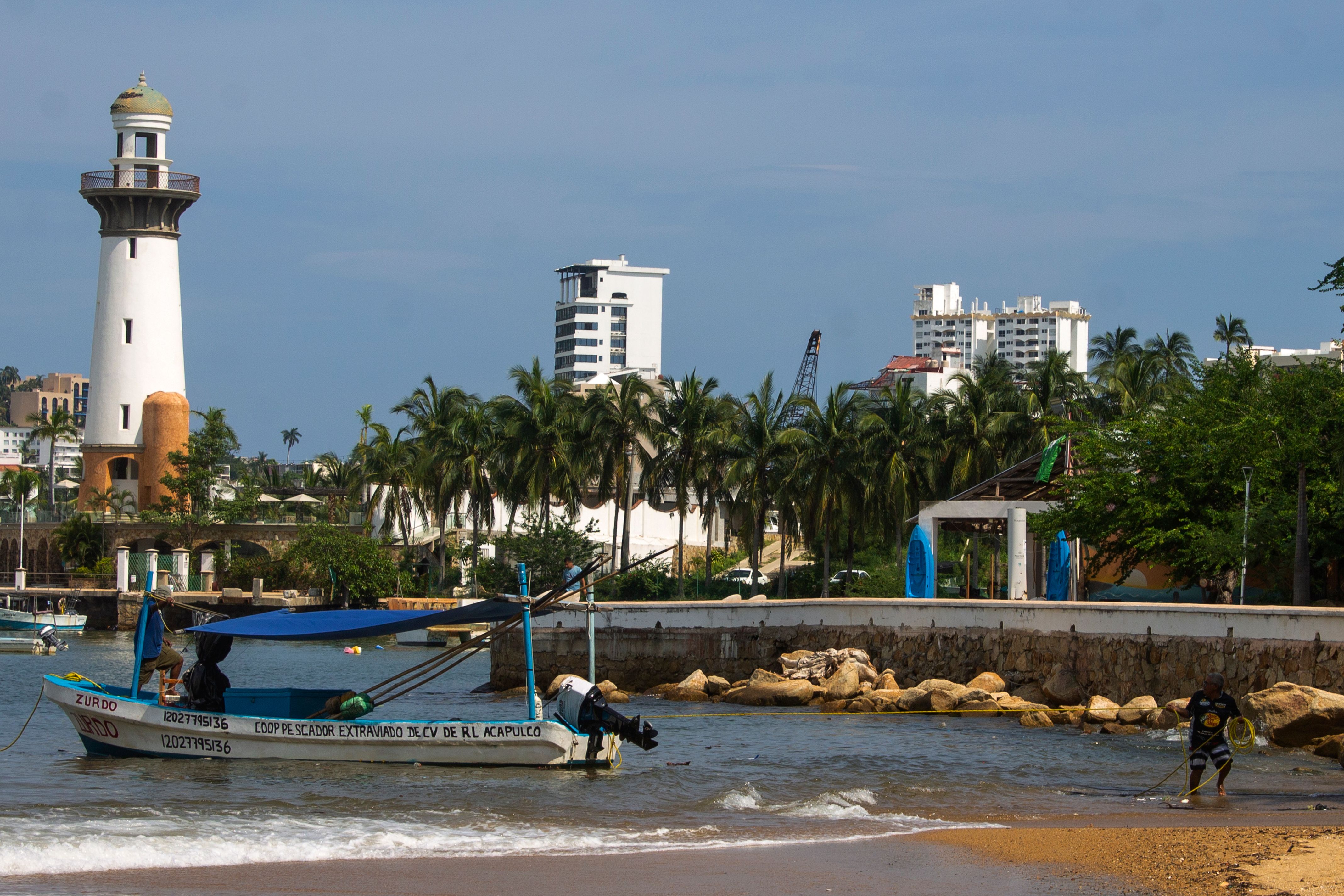 Lighthouse, fishing boat, and palm trees in Acapulco de Juarez, Mexico, captured on a sunny day.