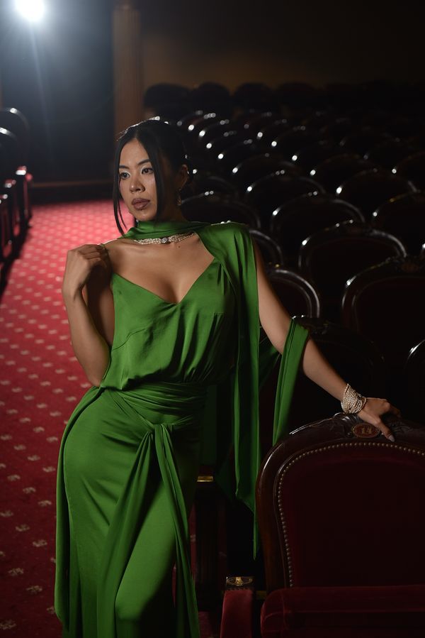 Woman in emerald green satin slip dress