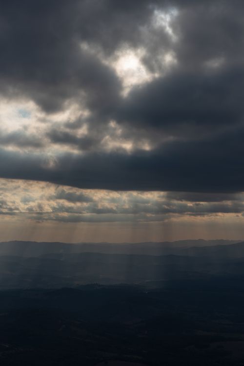 Free Dramatic skies with sunbeams piercing clouds over the hills of Minas Gerais, Brazil. Stock Photo