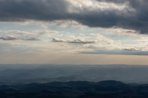 Free Dramatic clouds over rolling hills in Minas Gerais, Brazil during sunset. Stock Photo