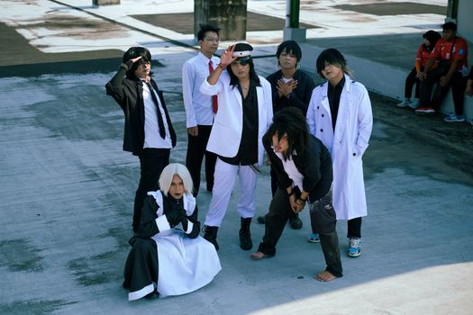 Young adults in creative cosplay outfits posing outside, showcasing unique fashion and expressions.