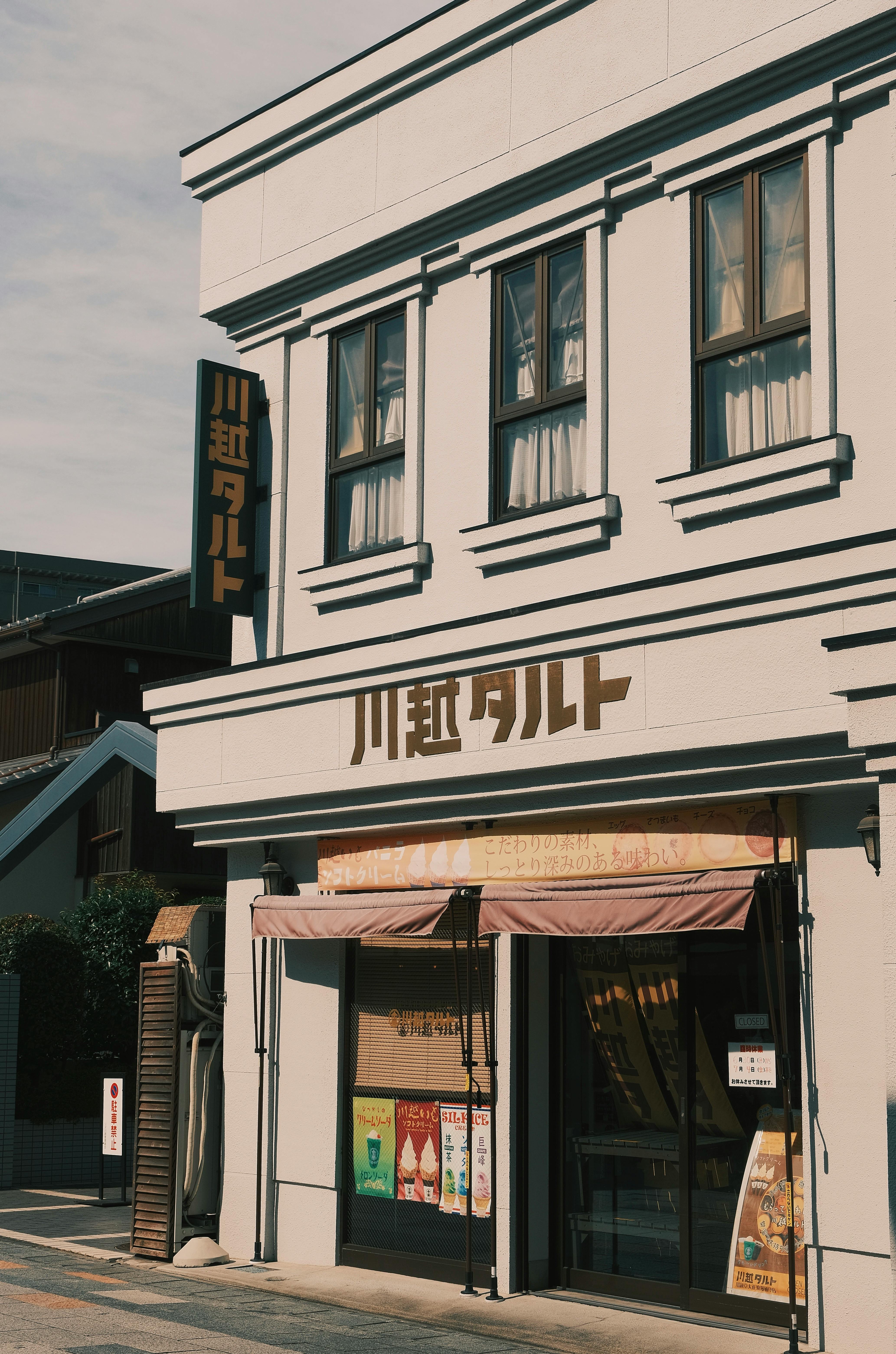 Free Bright facade of a Japanese bakery with signage and vintage architecture under daylight. Stock Photo