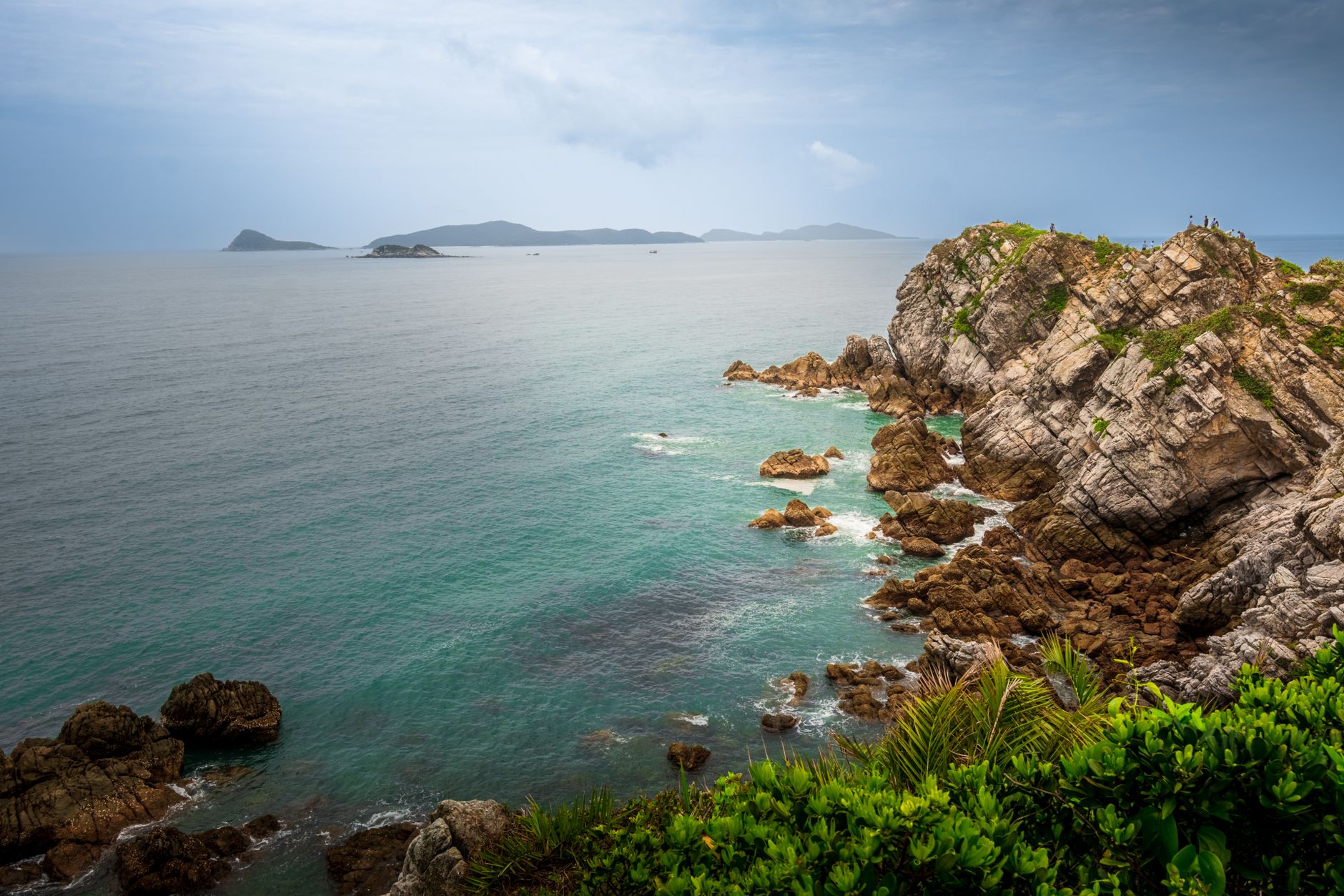 Beautiful coastal landscape in Quảng Ninh, Vietnam, featuring rugged rocks and distant islands.