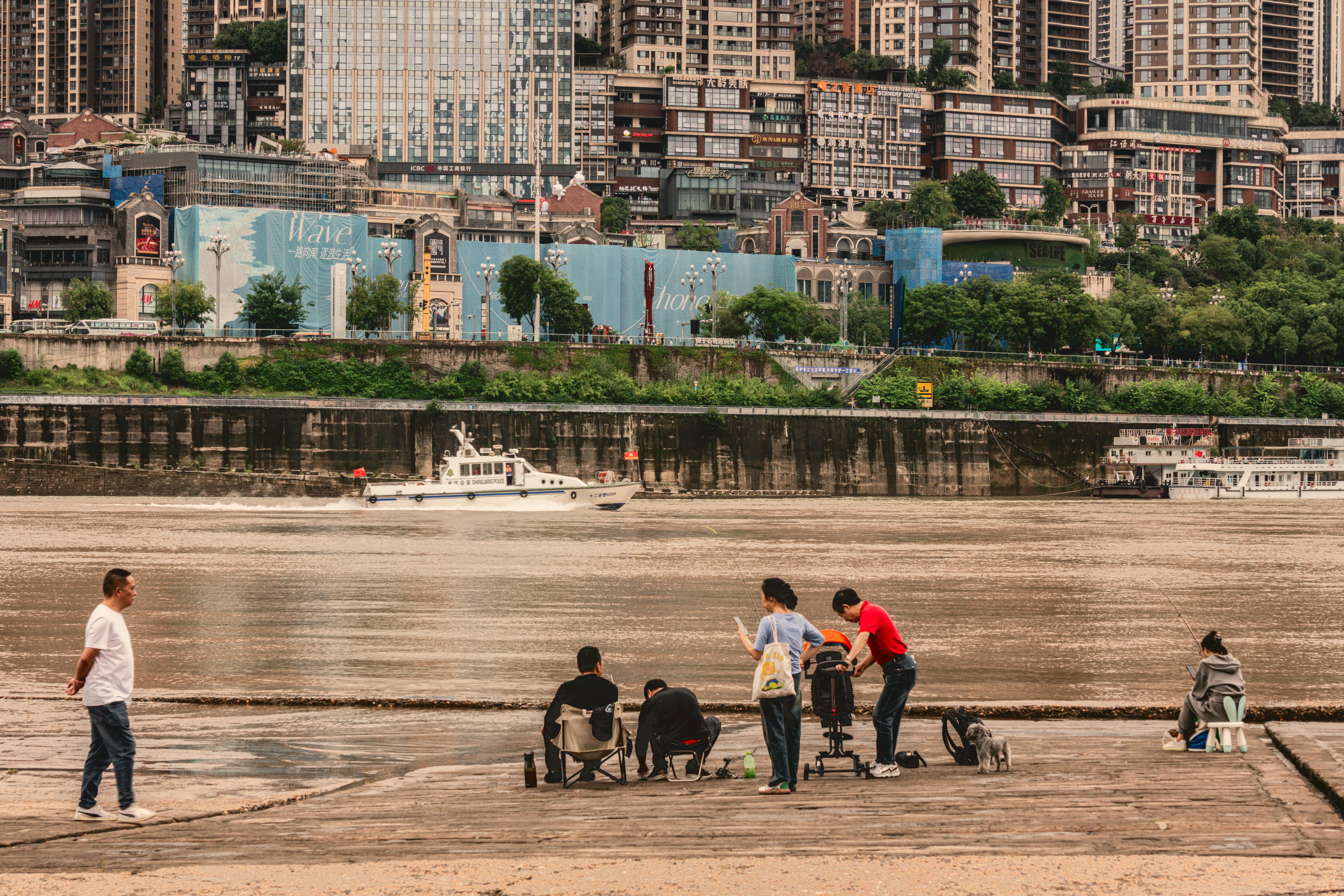 A group enjoying leisure time by the riverside against a city skyline, capturing a serene urban lifestyle.